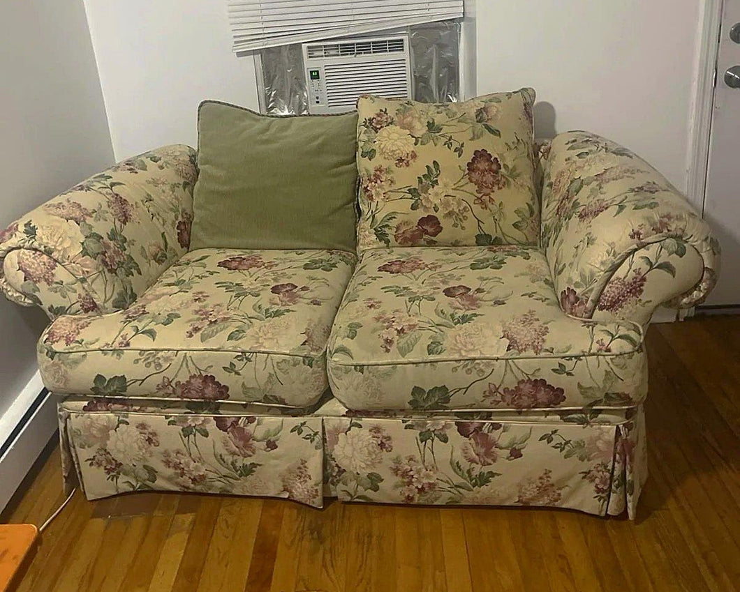 Two-seat floral loveseat shown from side angle